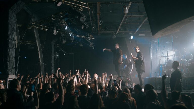 Band performing in a small concert venue in front of an energetic crowd